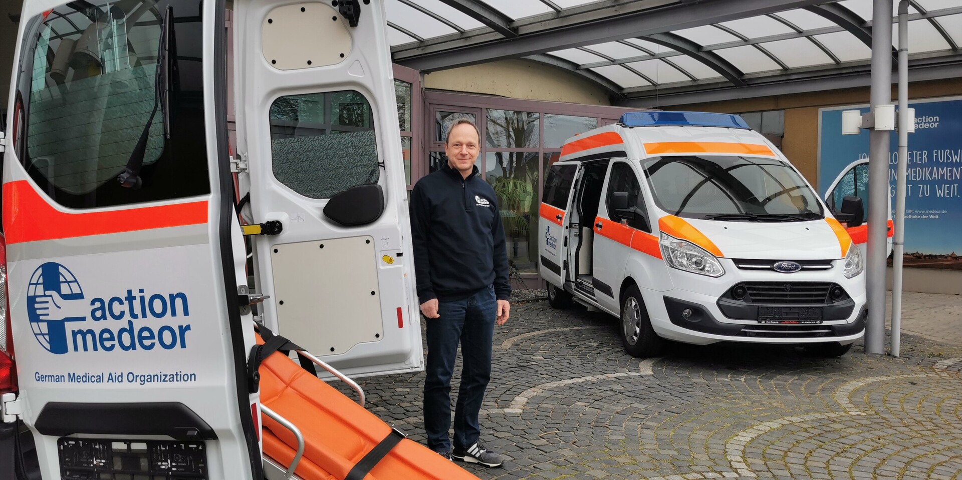 Christoph Bonsmann, Vorstand von action medeor steht vor einem Krankenwagen, der in die Ukraine geliefert werden soll