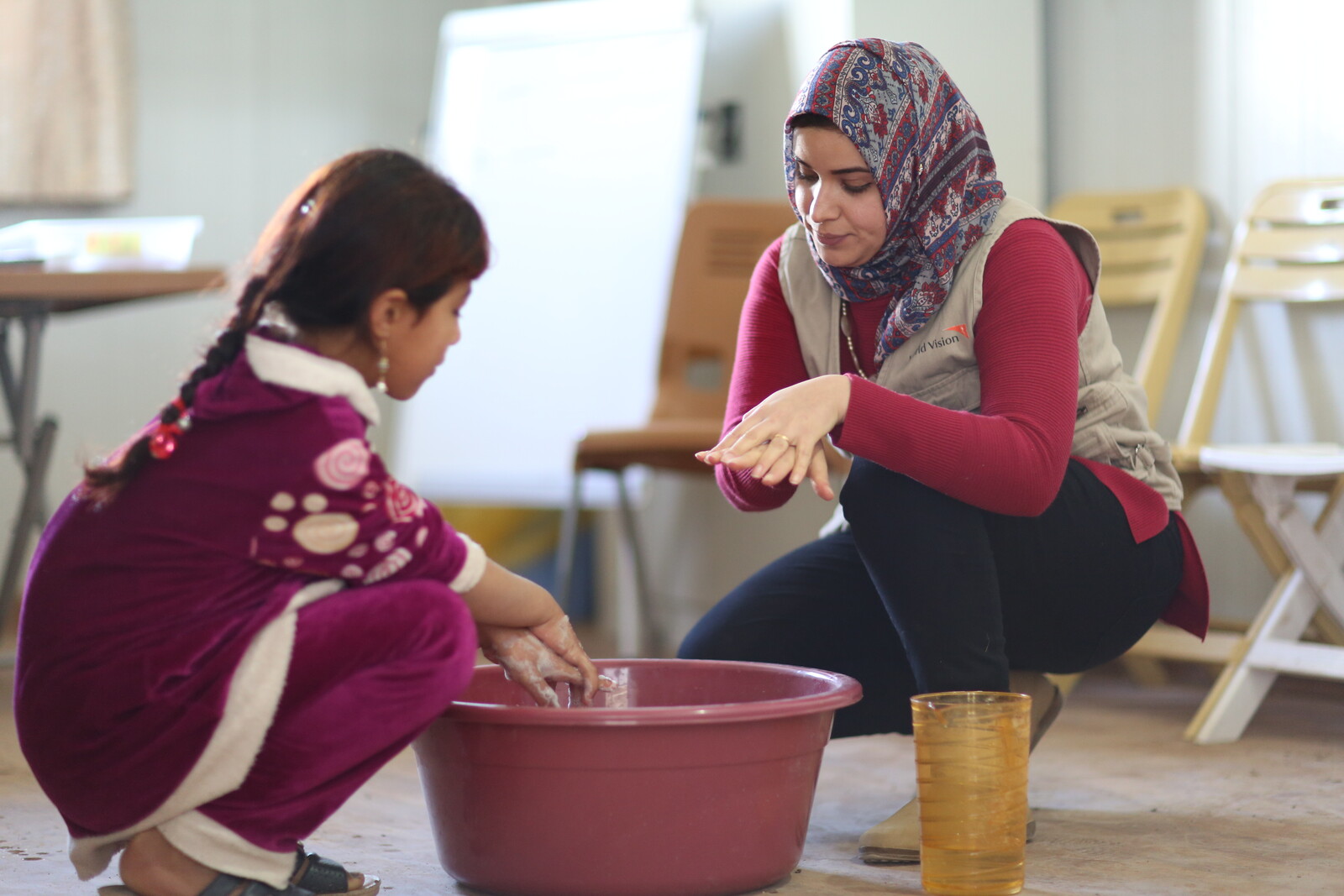 In einem Gesundheitszentrum im Irak zeigt eine Lehrerin einem Mädchen, wie richtiges Händewaschen geht 