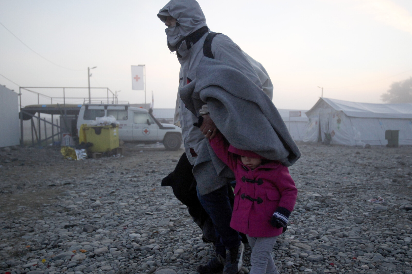 Eine Frau flieht mit einem kleinen Kind vor den Kämpfen in ihrer Heimat Syrien.