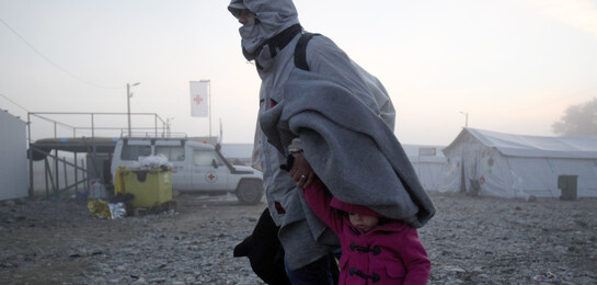 Eine Frau flieht mit einem kleinen Kind vor den Kämpfen in ihrer Heimat Syrien.