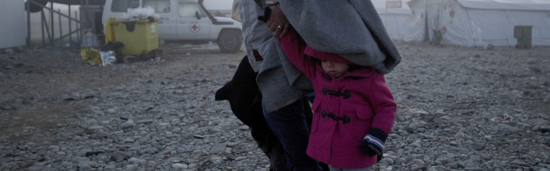 Eine Frau flieht mit einem kleinen Kind vor den Kämpfen in ihrer Heimat Syrien.