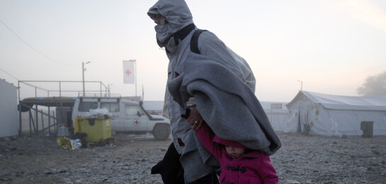 Eine Frau flieht mit einem kleinen Kind vor den Kämpfen in ihrer Heimat Syrien.