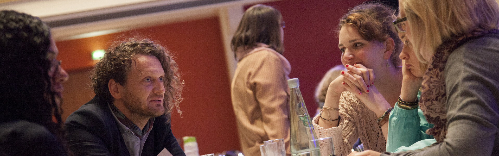 Menschen diskutieren in einem Raum miteinander.