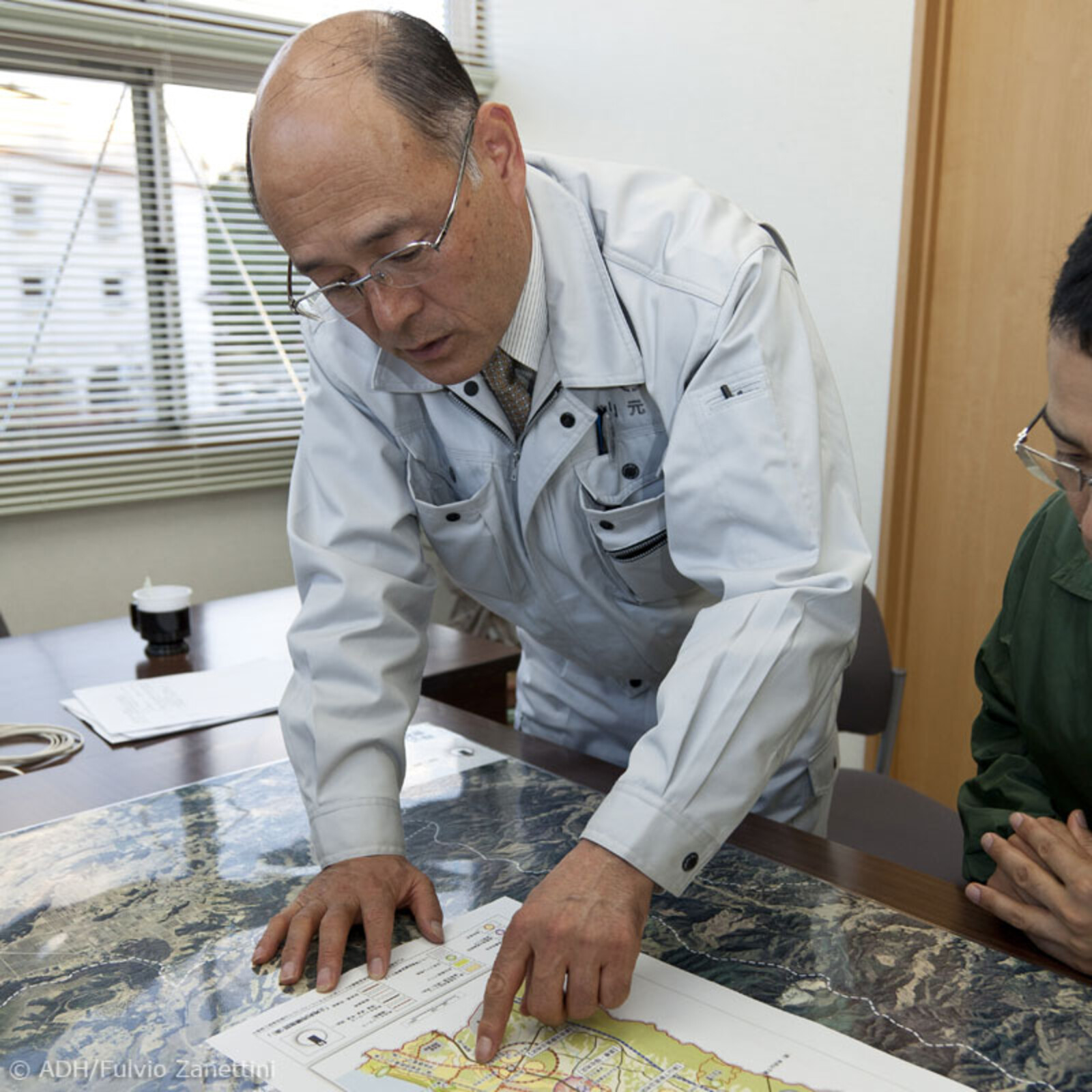 Herr Urashima von ADRA zeigt auf einer Karte die Zerstörungsausmaße des Tsunamis
