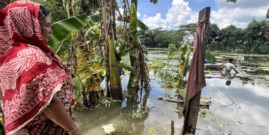 Eine Frau steht im Flutgebiet in Bangladesch