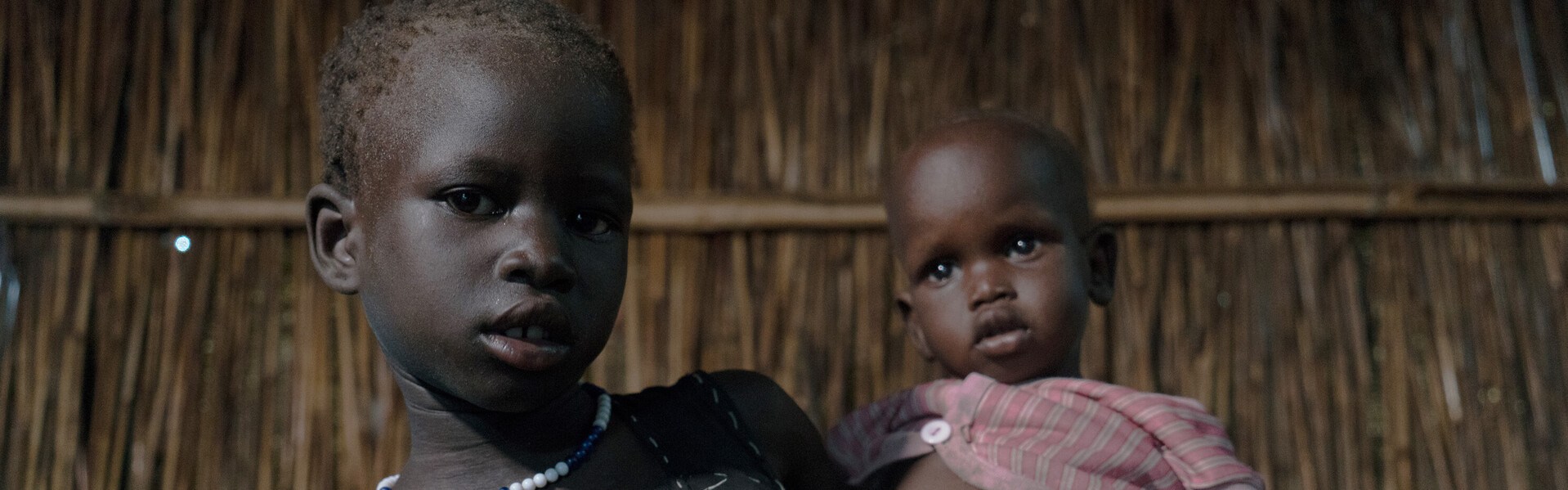 Ein Kind hält ein Baby im Arm im Südsudan. Beide sind Flüchtlinge.