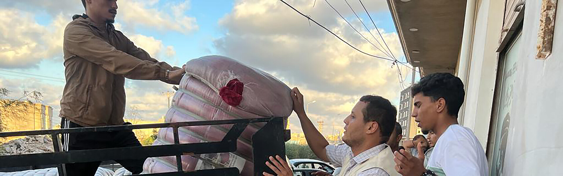 Helfer geben in Libyen Hilfsgüter für Flutbetroffene aus