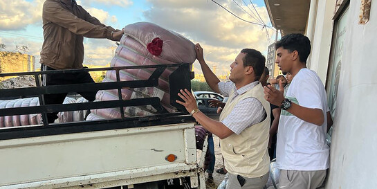 Helfer geben in Libyen Hilfsgüter für Flutbetroffene aus