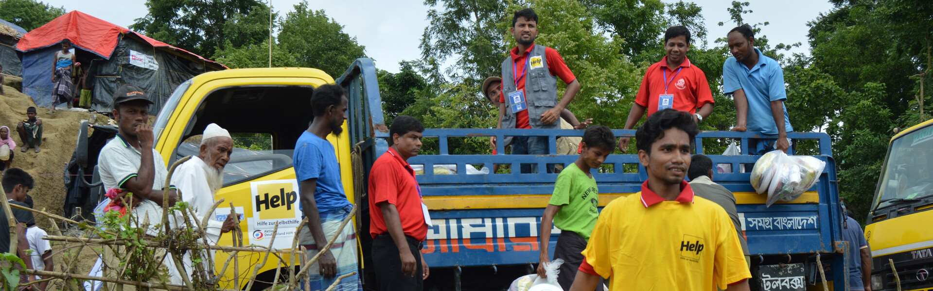 Helfer verteilen Hilfsgüter an Menschen in Bangladesch. Dort hat heftiger Monsunregen für Überschwemmungen gesorgt 
