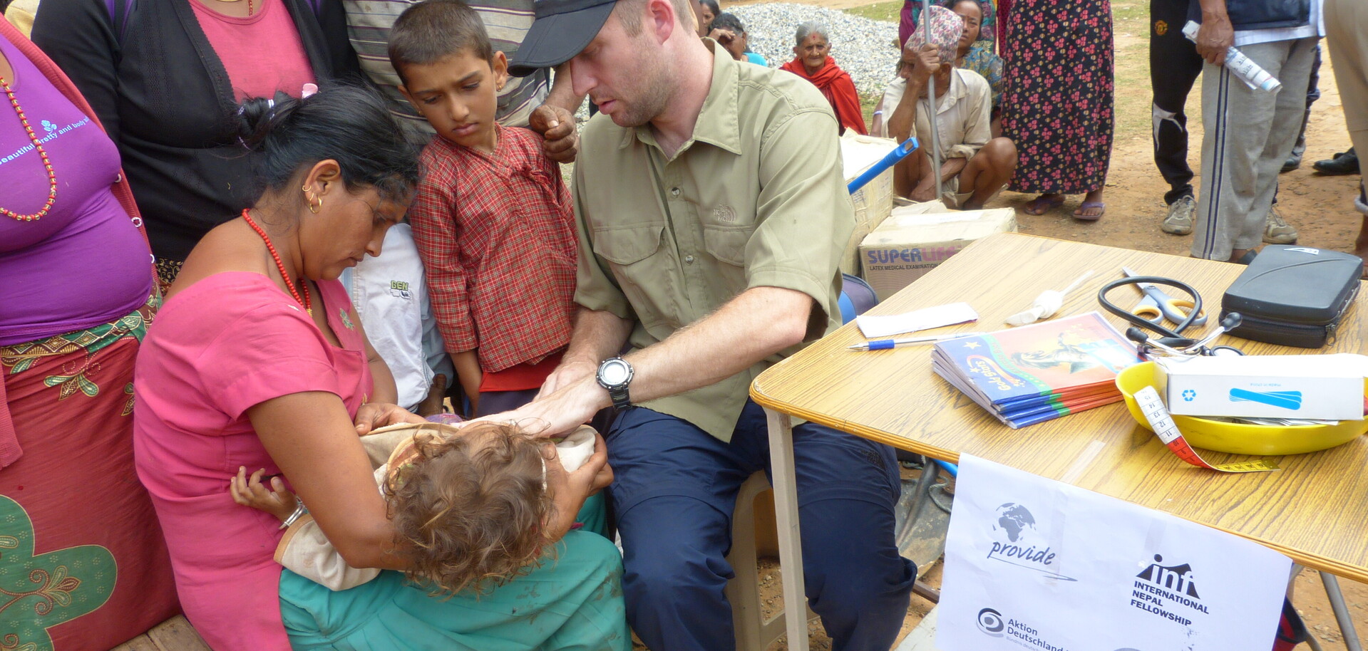 Nach dem Erdbeben in Nepal gibt es viele Verletzte. Eine Frau mit ihrem Kind wird von einem Arzt versorgt.