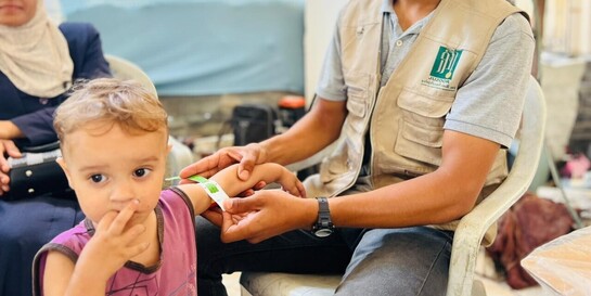 Ein Helfer in Gaza untersucht den Grad der Unterernährung eines Kindes