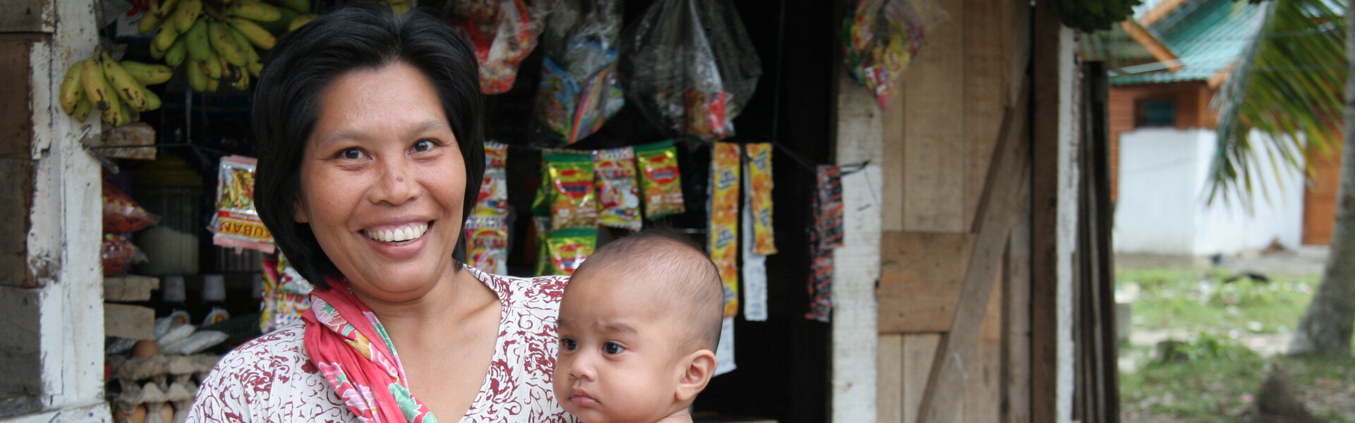 In Indonesien hält eine Frau ein Kind im Arm.