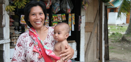 In Indonesien hält eine Frau ein Kind im Arm.