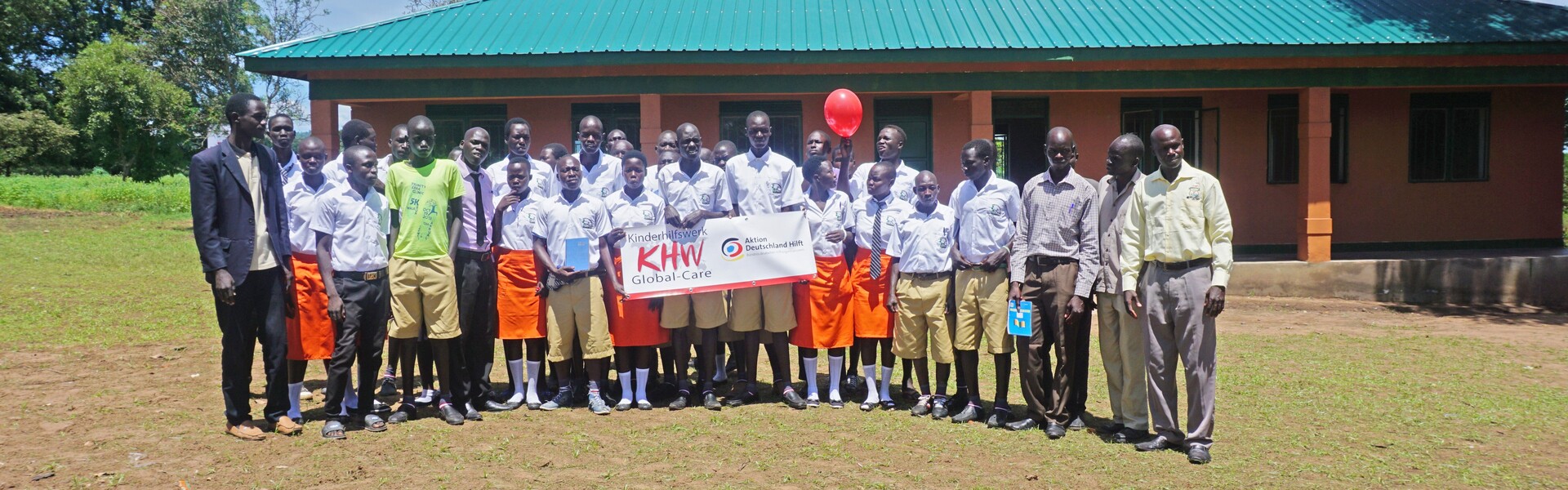 Kinder vor der neu gebauten Schule in einem Flüchtlingscamp in Uganda