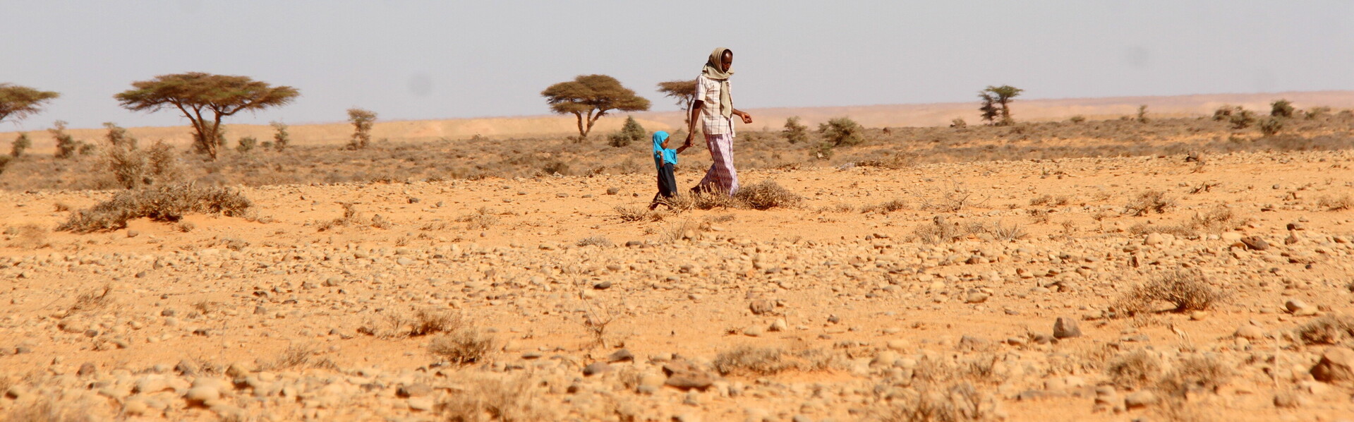 Frau mit Kind in einer Steppe in Somalia