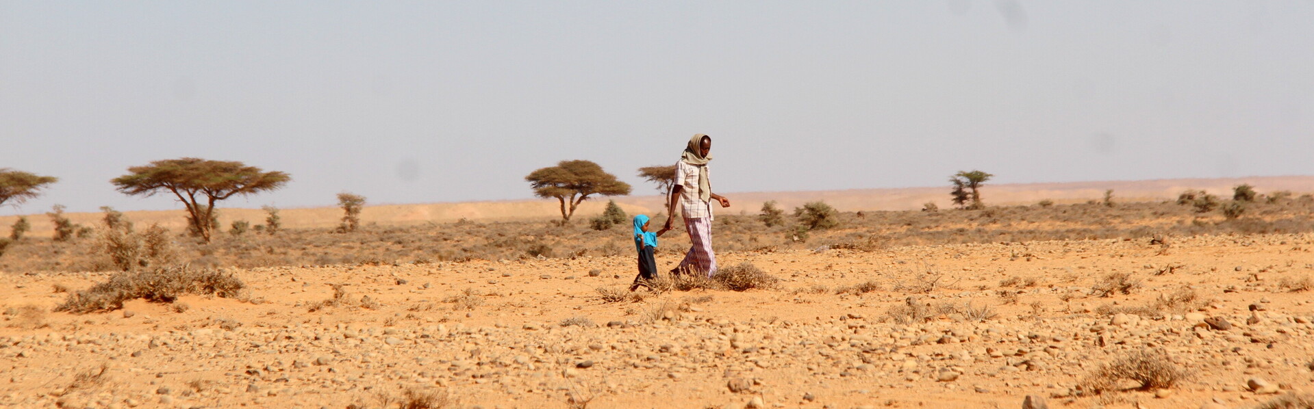 Frau mit Kind in einer Steppe in Somalia