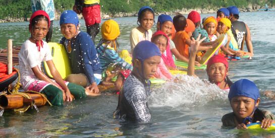 Kinder schwimmen im Wasser auf den Philippinen.
