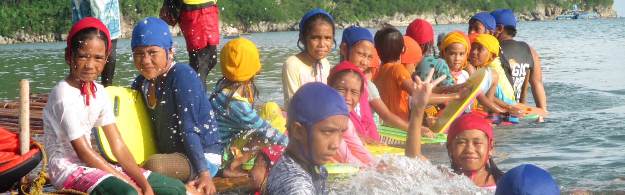Kinder schwimmen im Wasser auf den Philippinen.