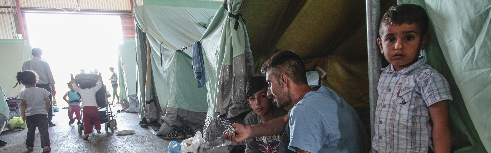Eine syrische Flüchtlingsfamilie sitzt vor ihrem Zelt
