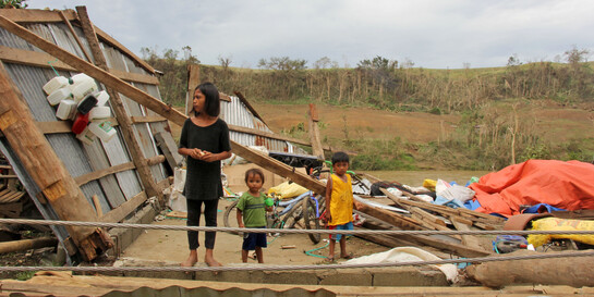Frau & Kinder inmitten der Zerstörung, die Taifun Mangkhut im Norden der Philippinen hinterließ