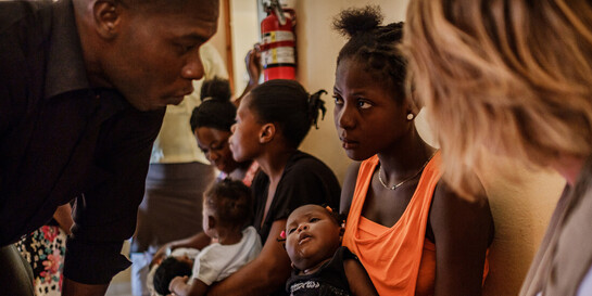 Helferin und zwei Haitianer in einer Notunterkunft