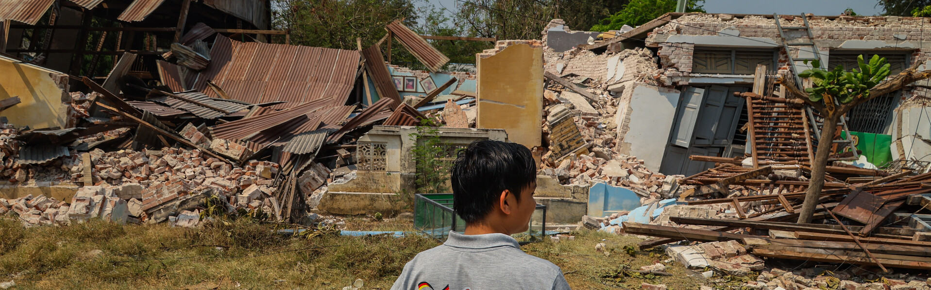 Ein Helfer vor den Trümmern, die das Erdbeben 2025 in Myanmar hinterlassen hat