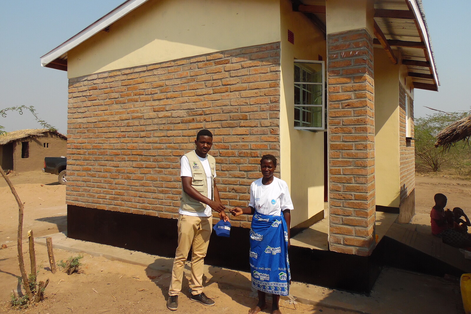 Menschen in Malawi vor einem neuen Haus