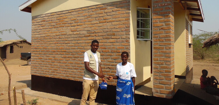 Menschen in Malawi vor einem neuen Haus