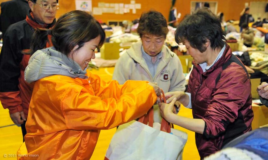 008-mitarbeiterin-lacht Lachend überreicht die Mitarbeiterin von World Vision die Taschen mit den Hygiene-Kits.