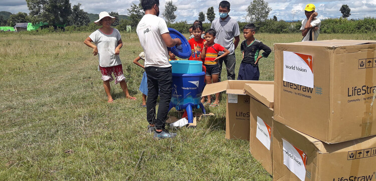 Ein Helfer der Organisation World Vision verteilt Essen an Kinder in Myanmar Ein Helfer der Organisation World Vision verteilt Essen an Kinder in Myanmar