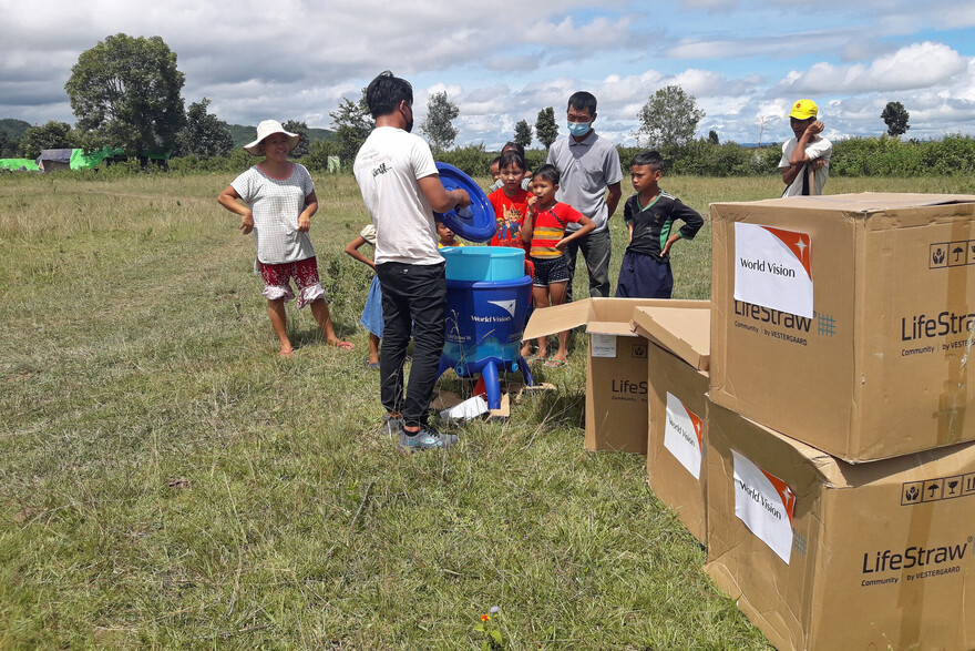 Ein Helfer der Organisation World Vision verteilt Essen an Kinder in Myanmar Ein Helfer der Organisation World Vision verteilt Essen an Kinder in Myanmar