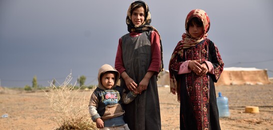 In Syrien stehen drei Flüchtlingskinder. Sie sind Betroeffene der Flüchtlingskrise in Syrien