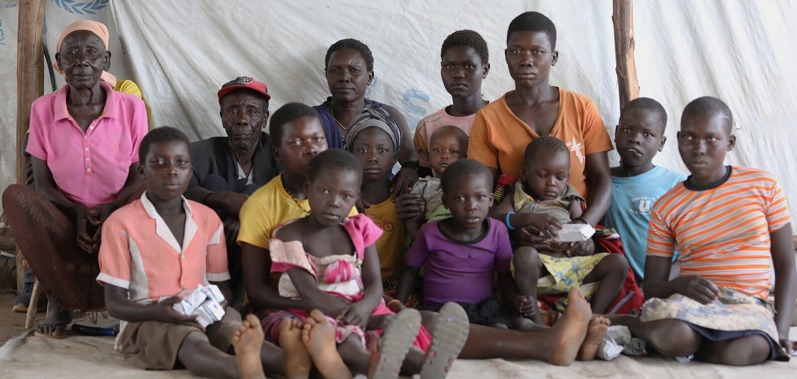 Vier Generation finden Zuflucht im Ankunftslager. Die Frau links ist über 100 Jahre alt, geflohen mit ihrem Bruder und seiner Frau (rechts davon) deren Kindern und Enkeln aus dem Südsudan.