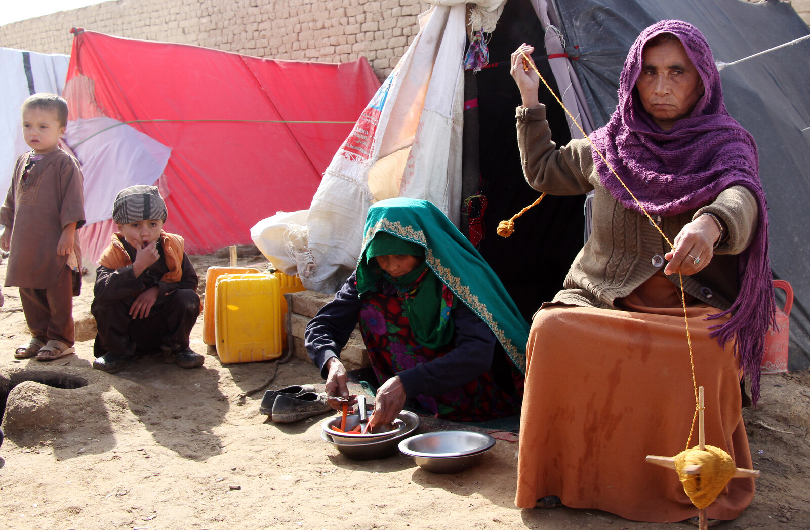 Eine Frau und ihre Kinder vor einer Notunterkunft in Afghanistan