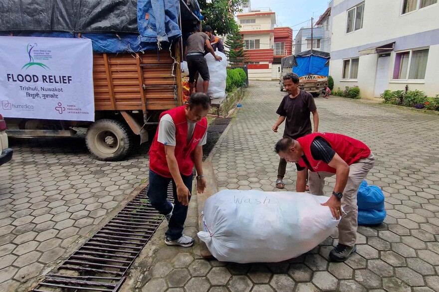 Humanitäre Helfer beladen ein Fahrzeug mit Hilfsgütern