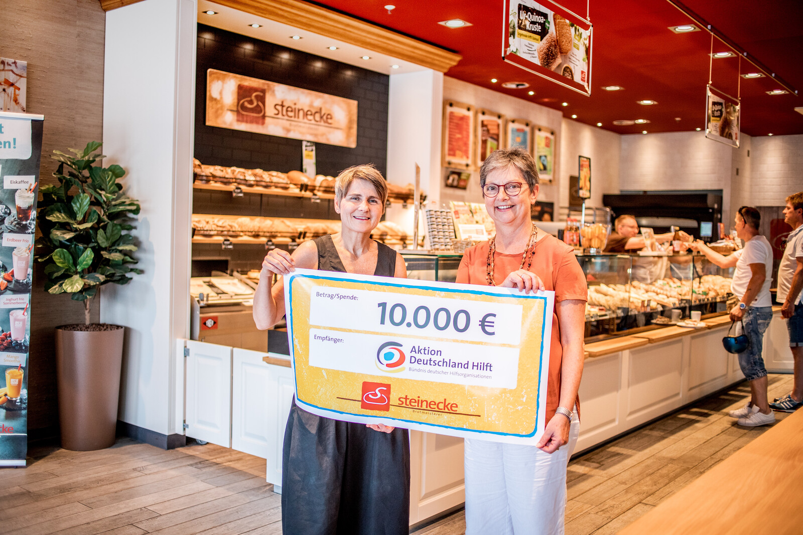 Katrin Steinecke und Manuela Roßbach, geschäftsführender Vorstand von Aktion Deutschland Hilft, bei einer Scheckübergabe der Brotmeisterei Steinecke