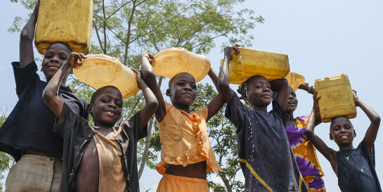 Kinder in Uganda mit gefüllten Wasserkanistern
