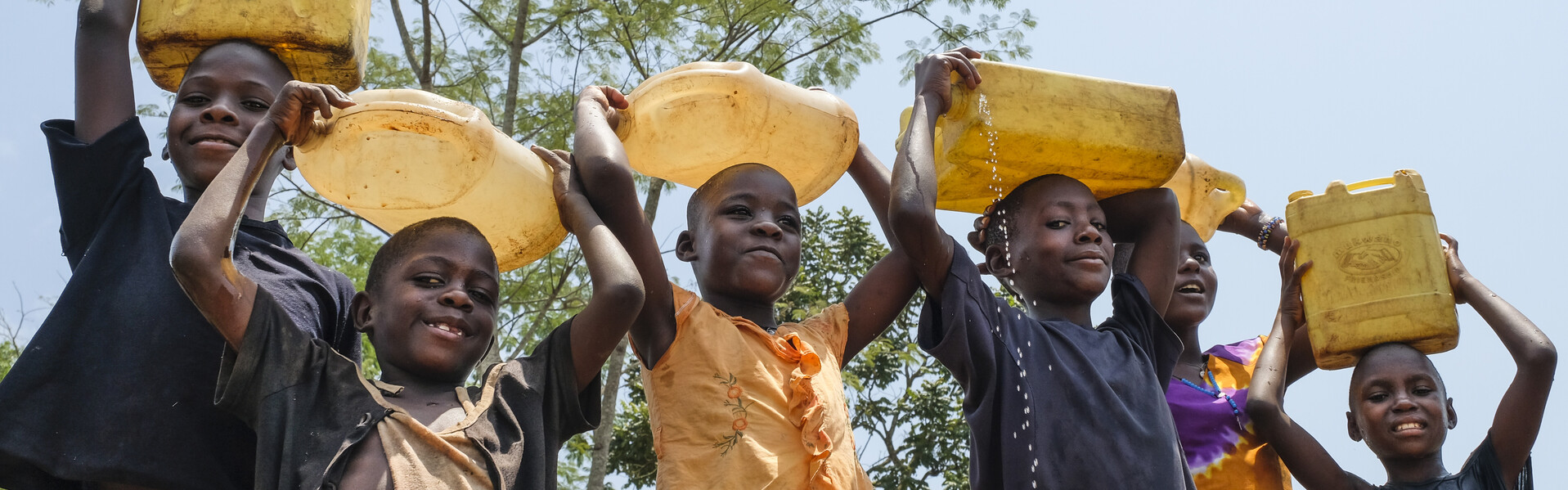 Kinder in Uganda mit gefüllten Wasserkanistern