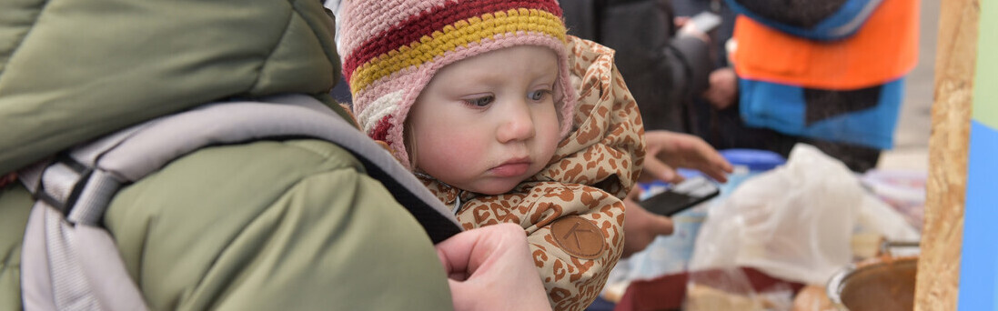 Eine Frau und ihr Baby aus der Ukraine werden von den Maltesern in Rumänien mit Essen versorgt