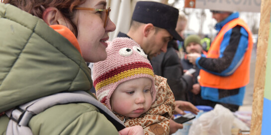 Eine Frau und ihr Baby aus der Ukraine werden von den Maltesern in Rumänien mit Essen versorgt