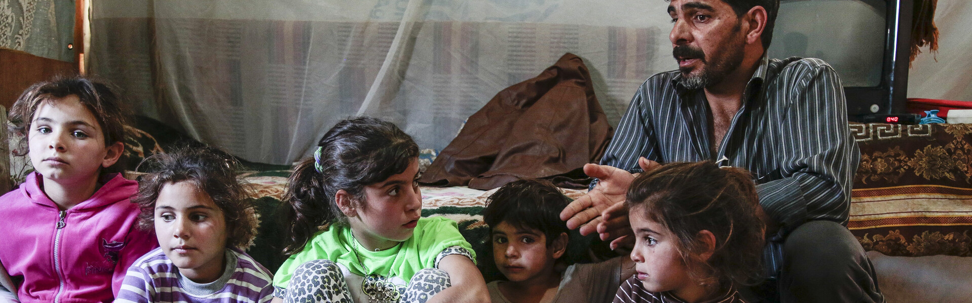 Eine Familie sitzt in ihrem Flüchtlingszelt.