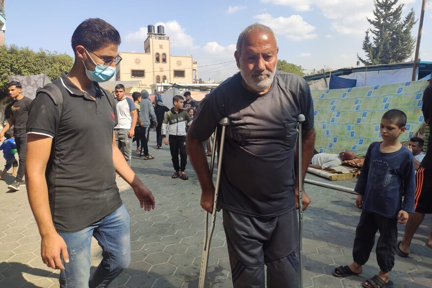 Ein Helfer in Gaza mit einem Mann, der Gehhilfen benötigt Ein Helfer in Gaza mit einem Mann, der Gehhilfen benötigt