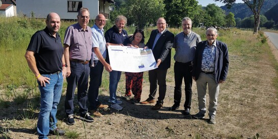 action medeor und Vertreter der Gemeinde Hönningen-Liers halten den Bauplan der neuen Tagespflege-Einrichtung in der Hand