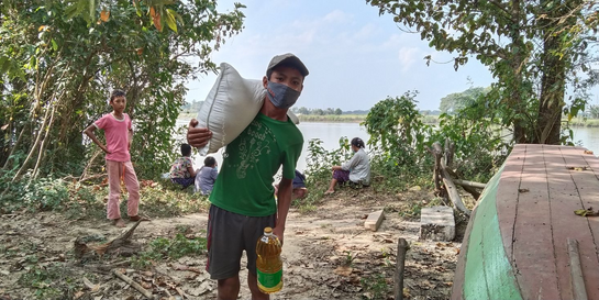 Kind mit Hilfsgütern in Myanmar