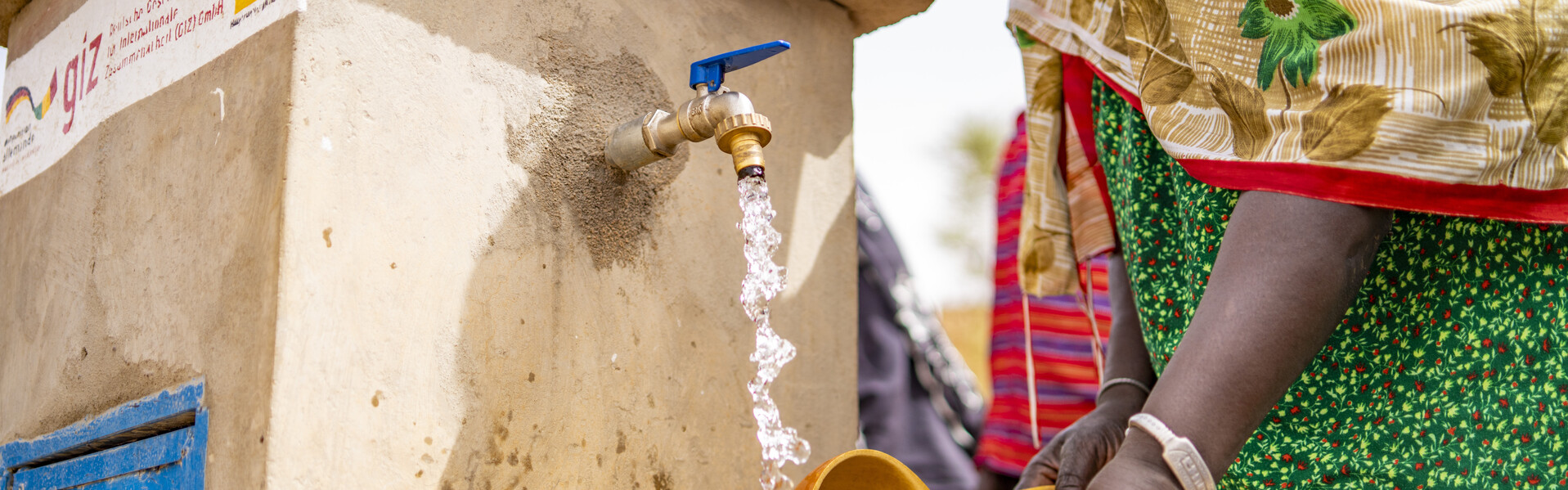 In Mali füllt eine Frau Wasser in einen Behälter (Symbolbild)