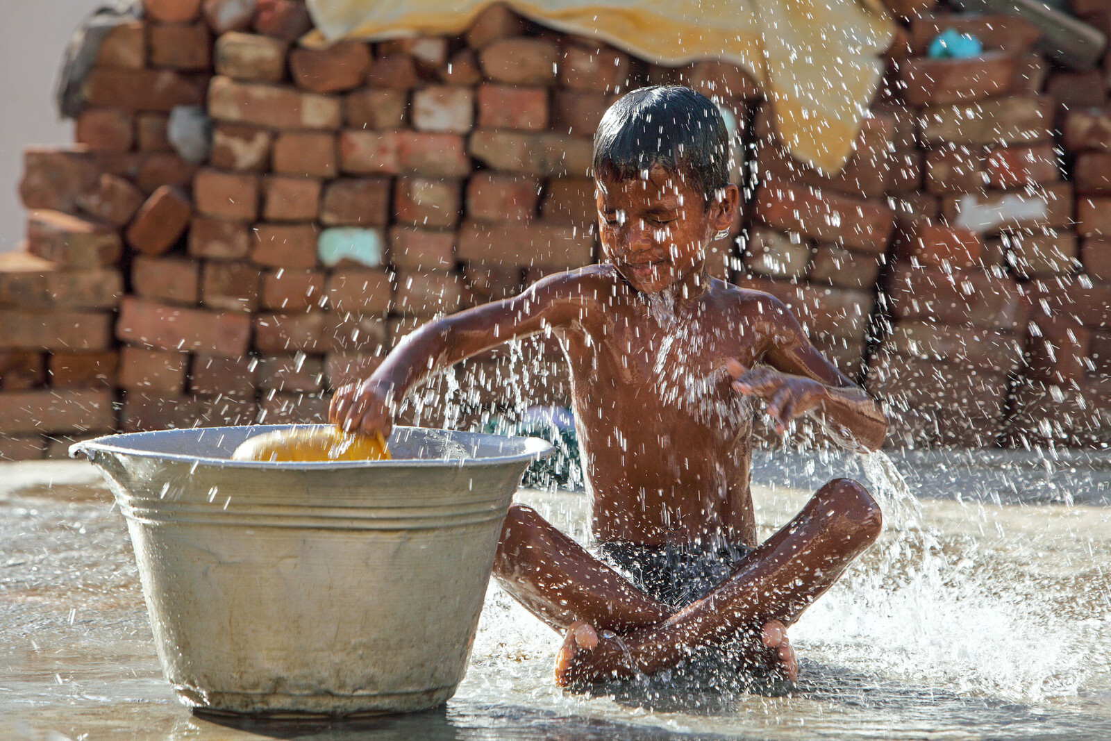Ein Junge spielt mit Wasser.