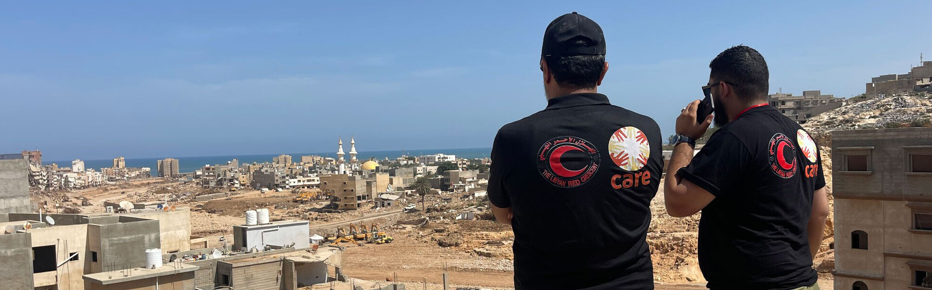 Zwei Helfer besprechen sich zur Lage nach der Flut in Libyen