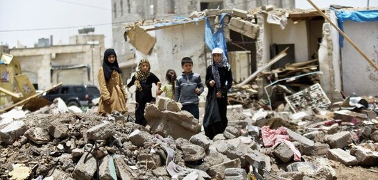 Kinder stehen in Ruinen in Syrien