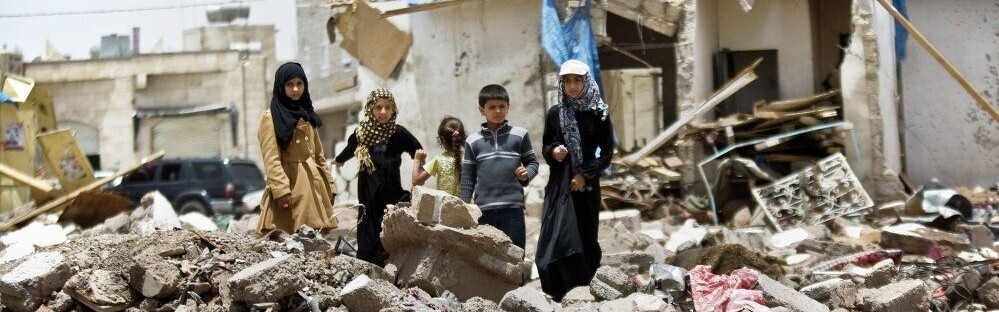 Kinder stehen in Ruinen in Syrien