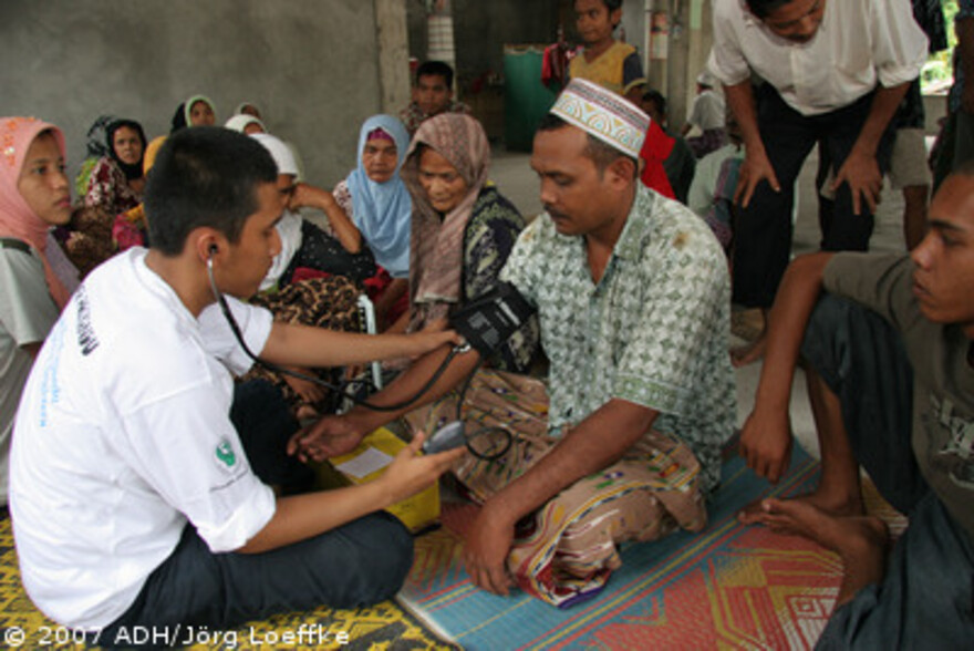 Tsunami-Hilfe Indonesien: Arzt misst Blutdruck bei einen Mann in Pasc Aceh Village